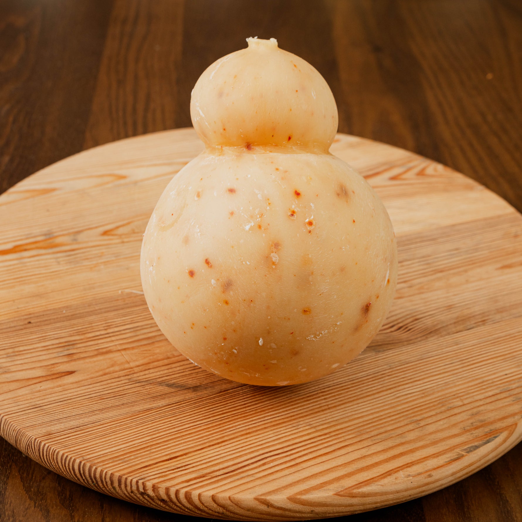 caciocavallo al peperoncino su tagliere di legno.