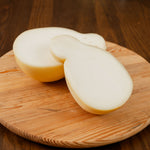 Caciocavallo semistagionato tagliato in due su tagiere di legno.