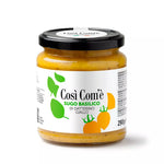 Vasetto di sugo di datterino giallo al basilico su sfondo bianco.