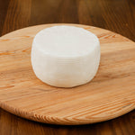 Formaggio primosale di capra su tagliere di legno.