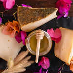 formaggio caprino con miele e fiori eduli su tagliere rustico.
