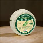 Formaggio fresco di pecora prataiola alla rucola su tagliere di legno.