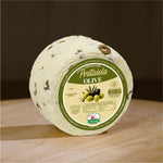 Formaggio fresco di pecora prataiola alle olive su tagliere di legno.