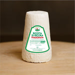 Ricotta di pecora stagionata su tagliere di legno.