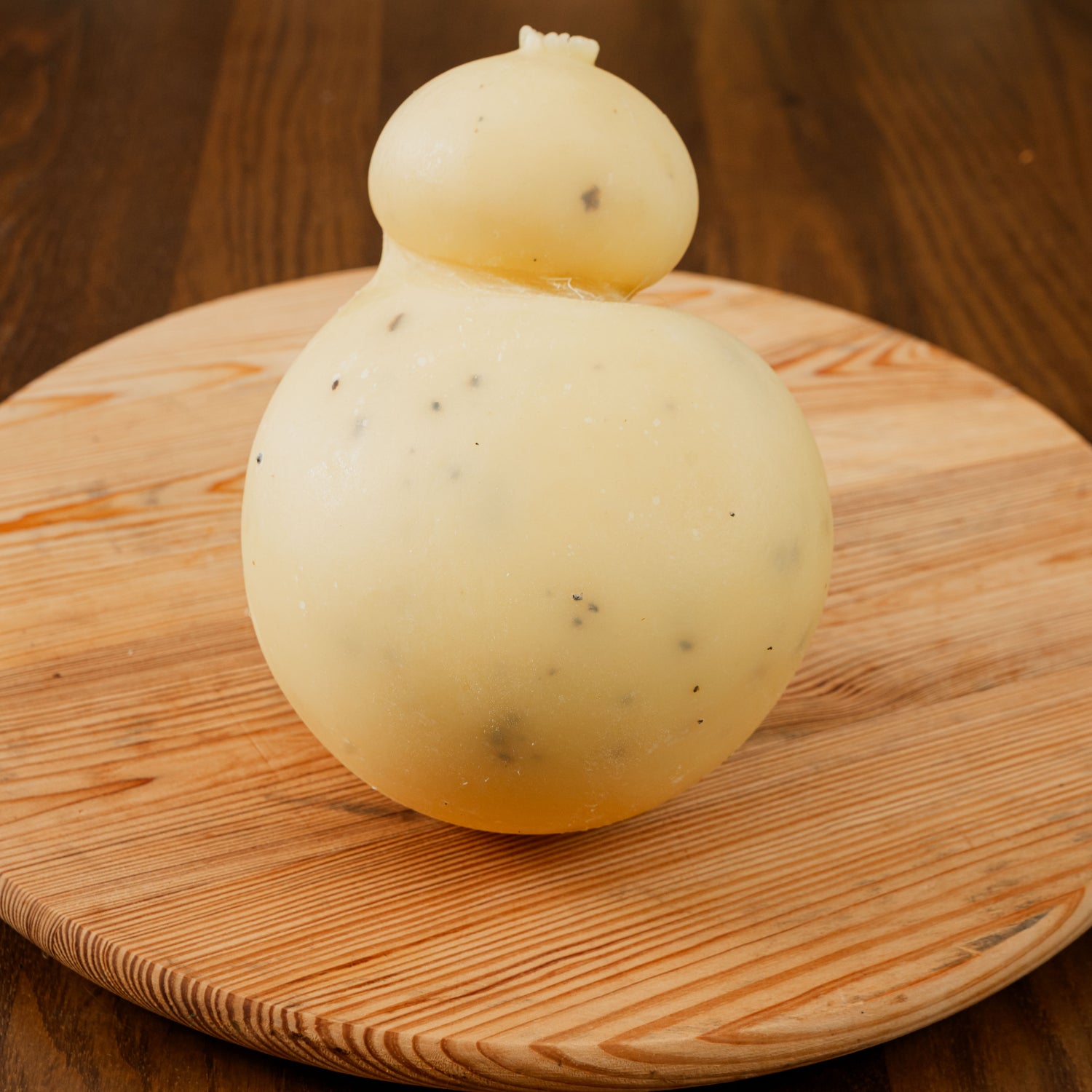 Caciocavallo al tartufo su tagliere di legno.