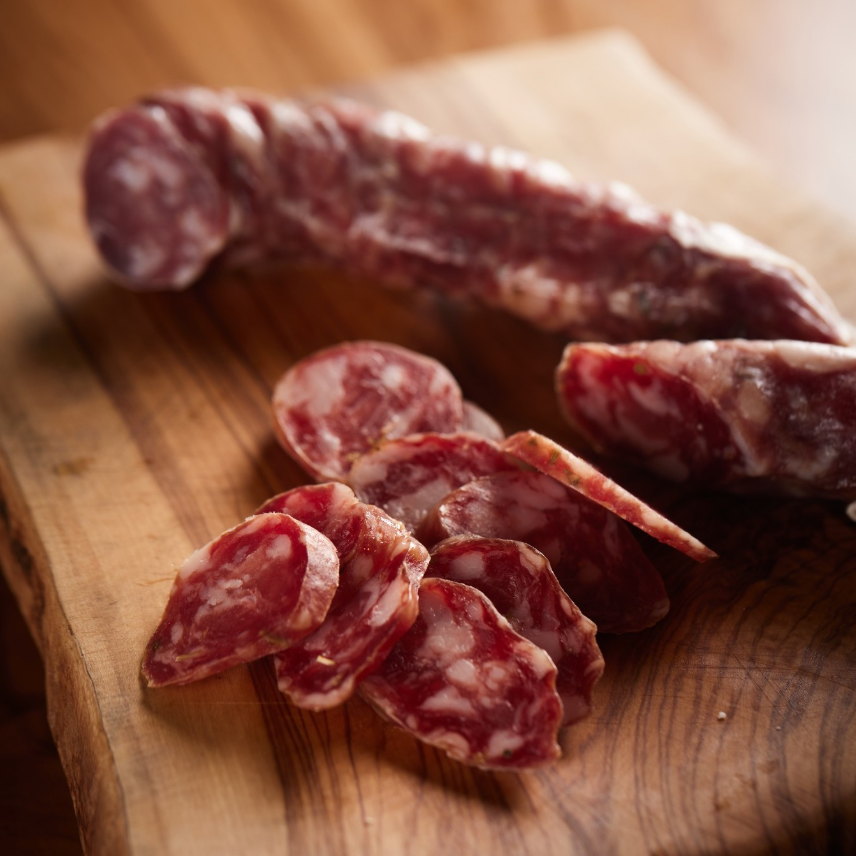 Salsiccia Cilentana tagliata a fette su tagliere rustico.