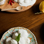Bocconi di mozzarella di bufala freschi su piatto decorato con foglia di basilico