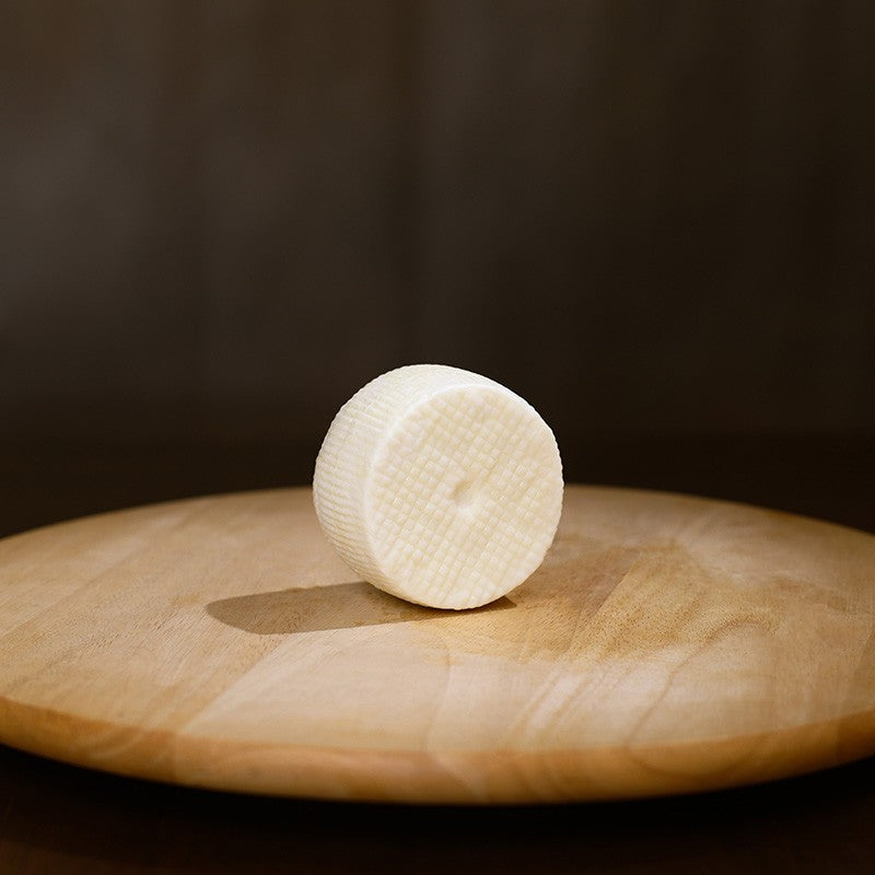 Retro Cacioricotta di capra su tagliere di legno.