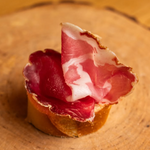 Capocollo affettato su bruschetta di pane.