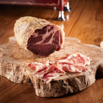 Capocollo affettato su tagliere di legno.