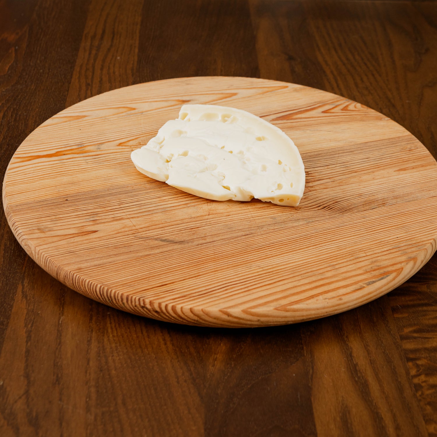 pezzo di formaggio caciocchiato lo conte su tagliere di legno.