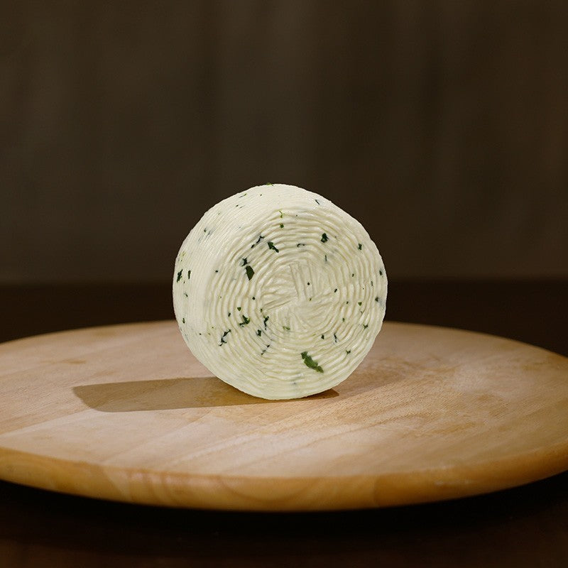 Retro formaggio fresco di pecora prataiola alla rucola su tagliere di legno.