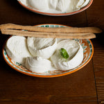 mozzarella aversana di latte di bufala  con pomodorini, bocconcini di mozzarella, foglia di basilico e grissini su piatti tradizionali.