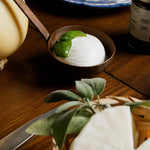 Mozzarella aversana di Bufala con foglia di basilico, caciocavallo e formaggio a pasta dura in cestino con foglie aromatiche.