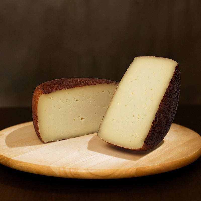 formaggio di pecora Pastorella Cilentana tagliata in due su tagliere di legno.