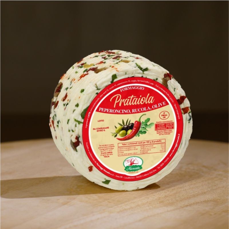 Formaggio fresco di pecora prataiola al peperoncino, rucola e olive su tagliere di legno. 