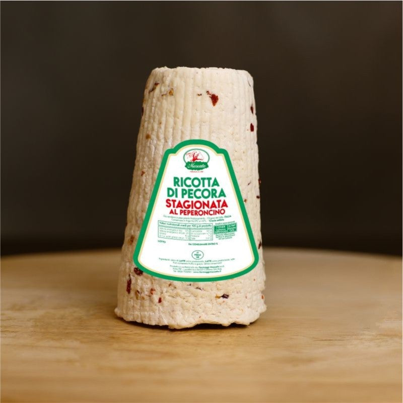 Ricotta di pecora stagionata al peperoncino su tagliere di legno.