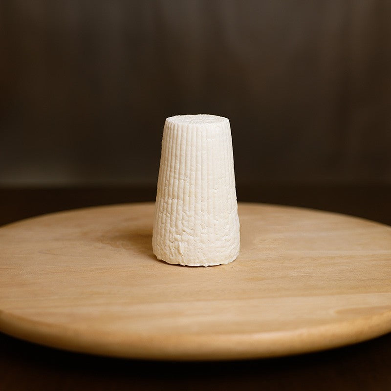 Retro di ricotta di pecora stagionata su tagliere di legno.